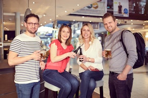 Vier Passagiere stoßen an Theke an