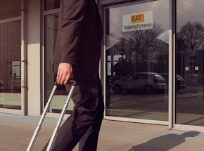 Mann mit Koffer Trolley vor dem GAT