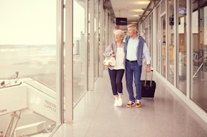 Learn more about us couple with trolley walking in terminal