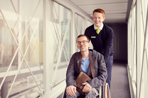 passenger with reduced mobility is getting pushed by airport staff 